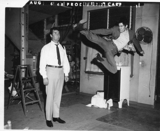 Bruce Lee practices a flying kick on James Garner on the set of Marlowe, 1968