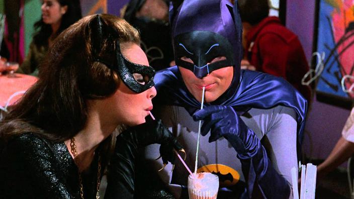 Batman and Catwoman sharing a drink