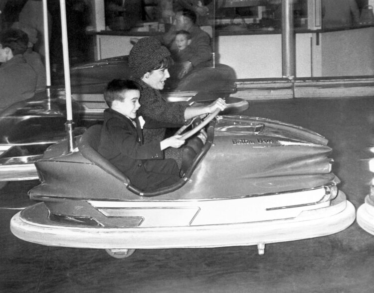 Elizabeth Taylor and her son Michael Wilding Jr. getting competitive during a rough round of bumper cars, circa 1961.
