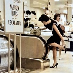 Women were reminded to be careful when wearing their narrow high heels before riding the escalator Gimbel’s Department Store Paramus, New Jersey 1966
